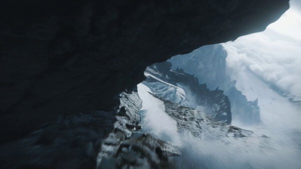 Camera plunges along a craggy alpine ridge